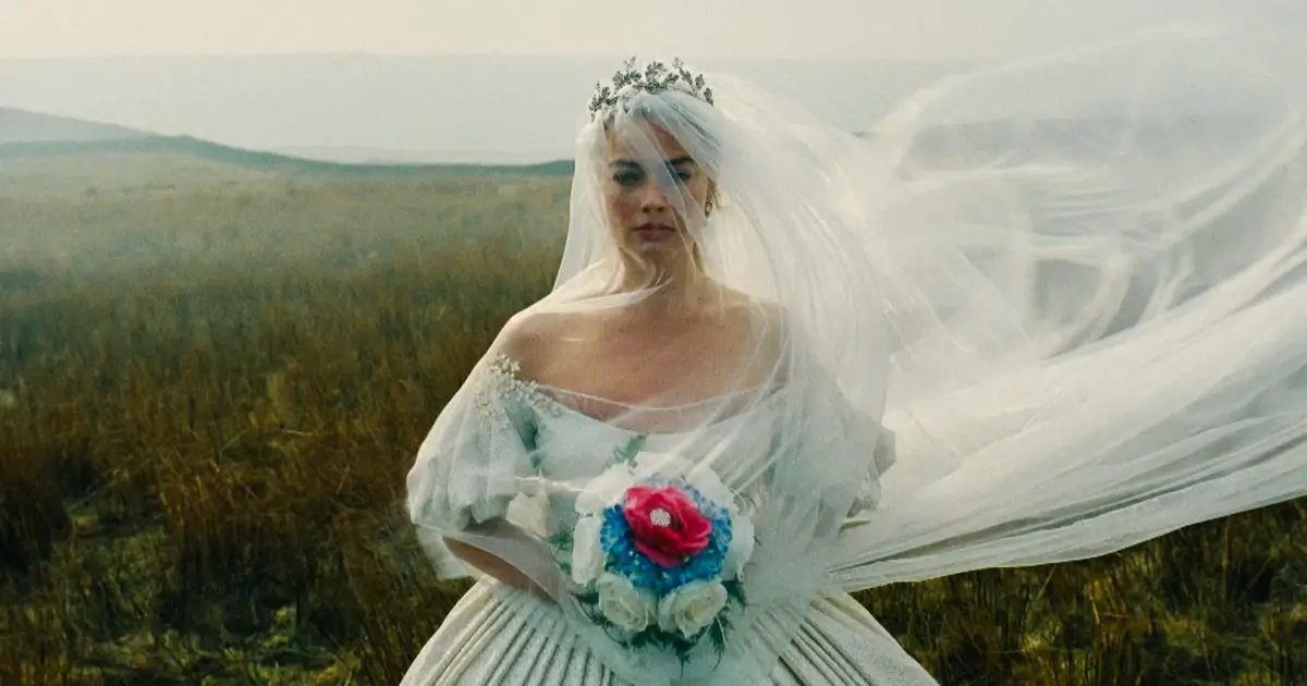 Margot Robbie em cena de “O Morro dos Ventos Uivantes” (2026), vestida de noiva em campo aberto — uma das estreias de 12 de fevereiro de 2026.