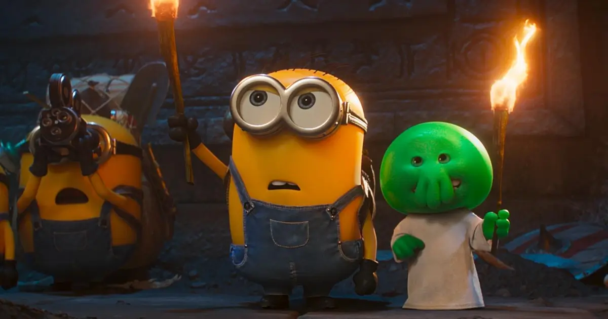 Minions e uma criatura verde seguram tochas em cena do trailer de Minions e Monstros (2026)