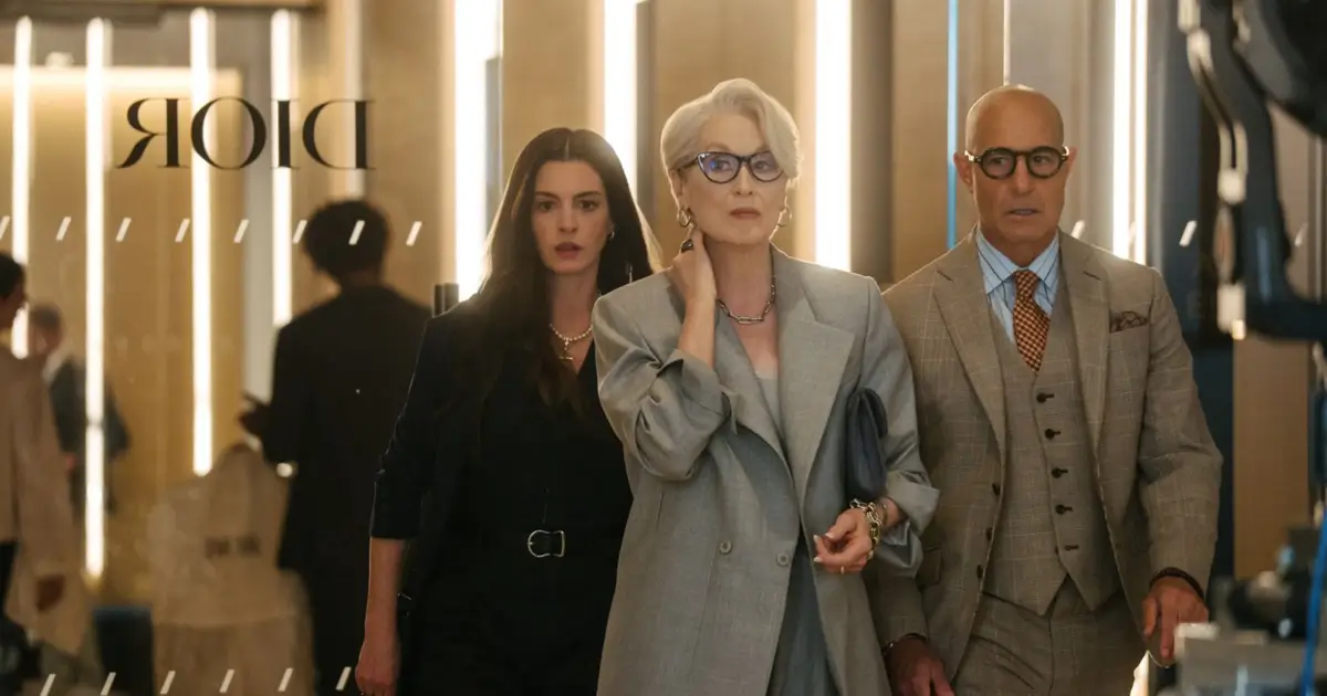Meryl Streep, Anne Hathaway e Stanley Tucci em cena de “O Diabo Veste Prada 2” (2026), caminhando por um corredor elegante.