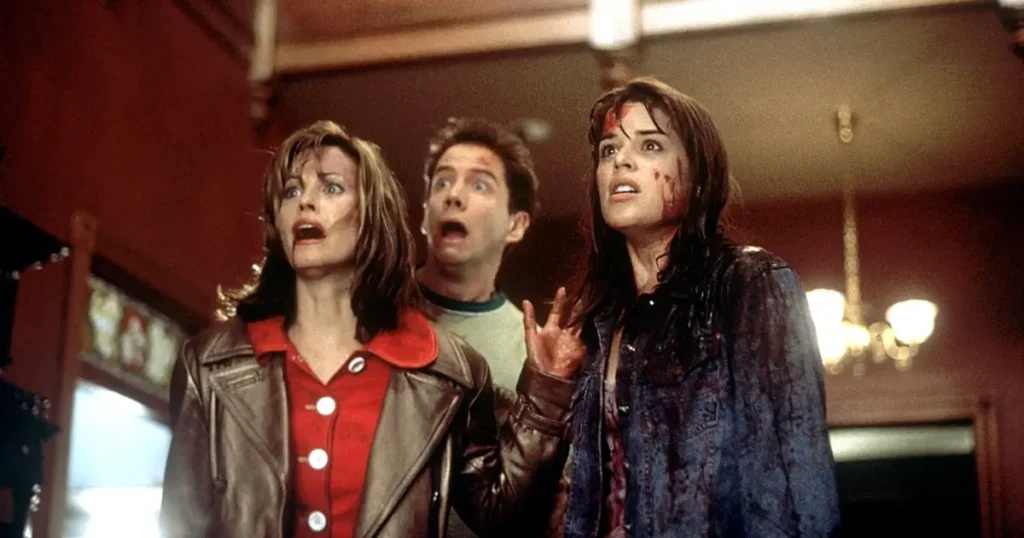 Sidney Prescott, Gale Weathers e Randy Meeks em cena tensa de Pânico (1996).
