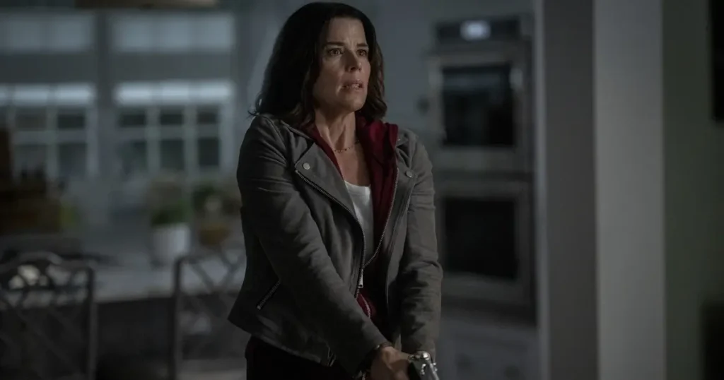 Sidney Prescott segurando uma arma em Pânico 7, pronta para proteger sua família de uma nova ameaça.