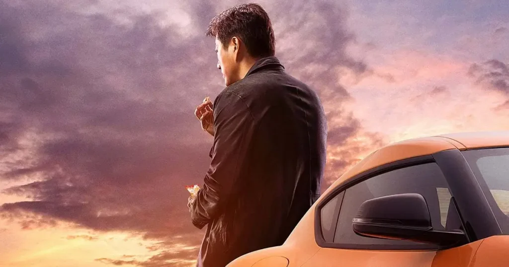 Han, interpretado por Sung Kang, de costas ao lado de um carro em sua cena de retorno em Velozes & Furiosos 9.