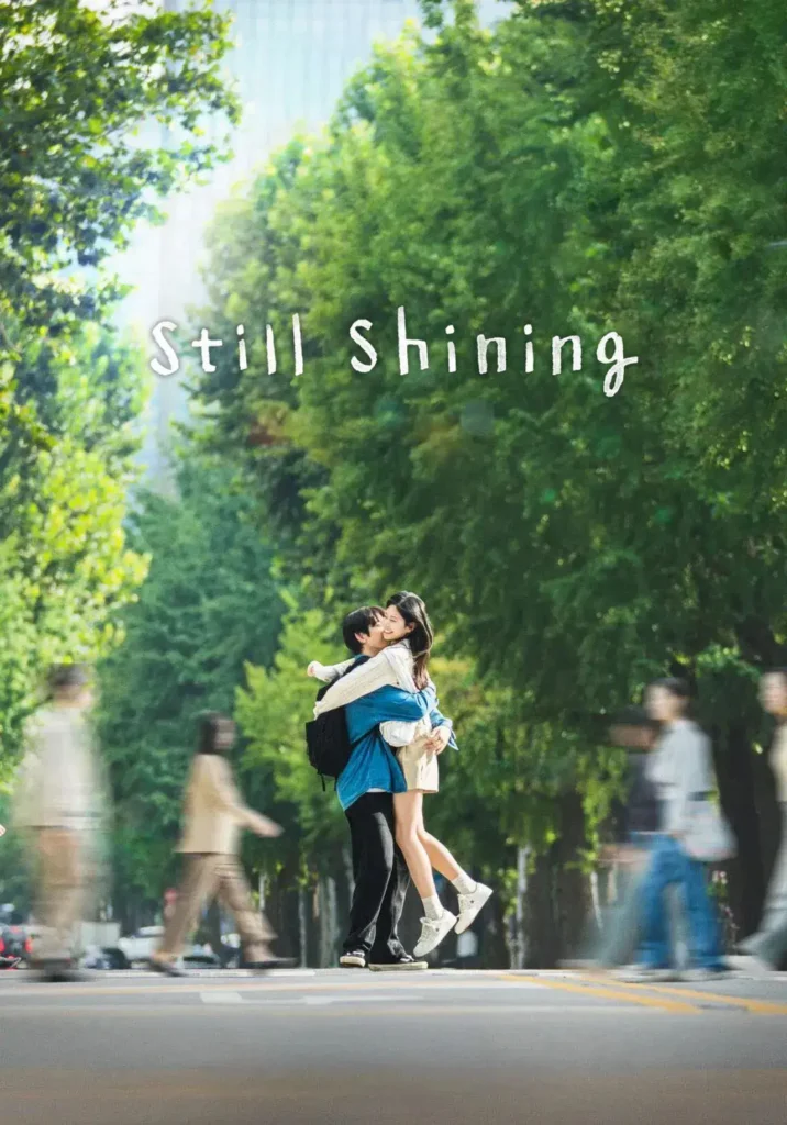 Pôster de Um Amor que Ilumina (Still Shining), mostrando Park Jin-young abraçando Kim Min-ju no meio da rua cercada por árvores.