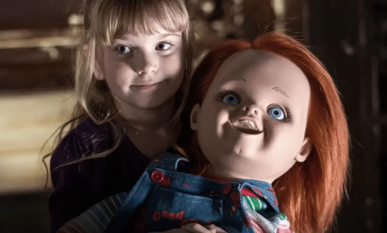 Summer H. Howell ao lado de Chucky em cena de A Maldição de Chucky (2013), quinto filme da franquia Brinquedo Assassino