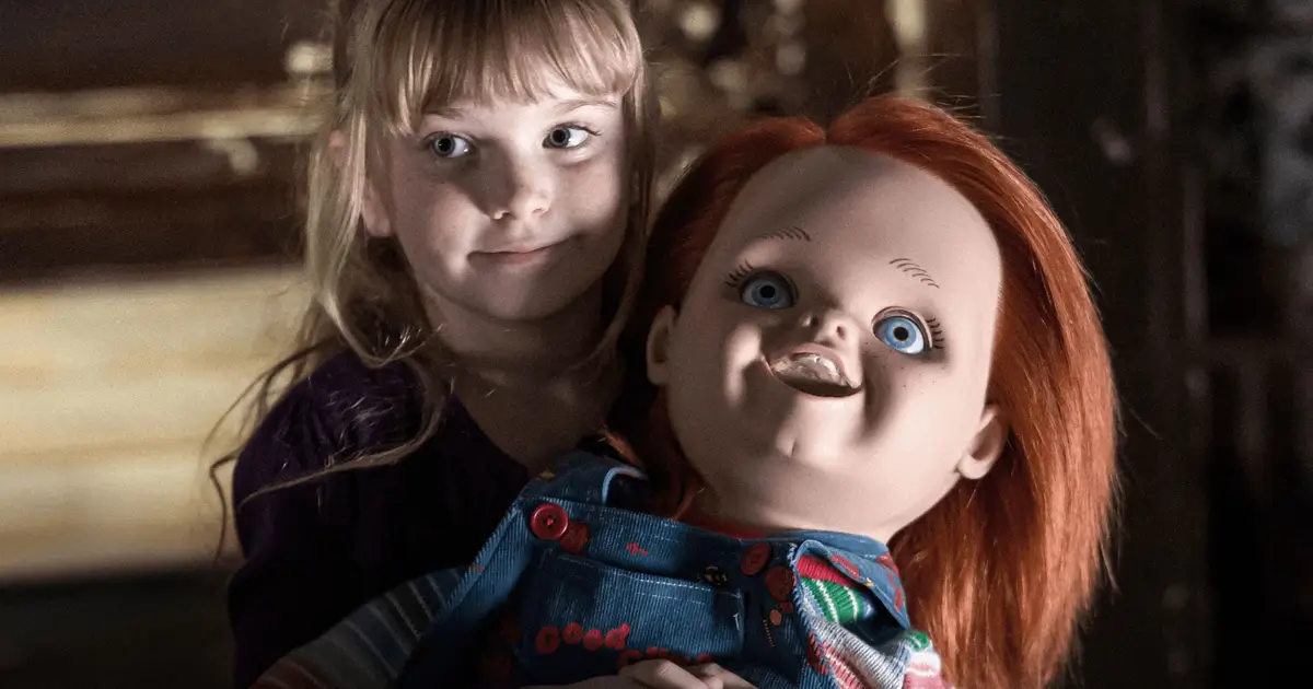 Summer H. Howell ao lado de Chucky em cena de A Maldição de Chucky (2013), quinto filme da franquia Brinquedo Assassino