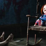 Boneco Chucky sentado em cadeira de balanço em cena do filme A Maldição de Chucky (2013)