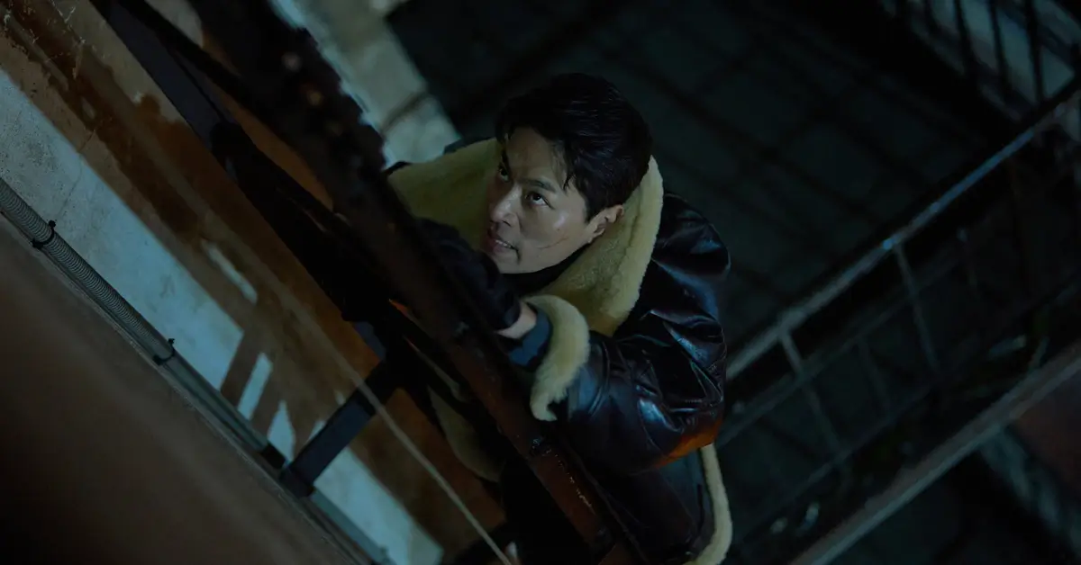 Park Jeong-min em cena de ação no trailer de Inteligência Humana (2026), escalando estrutura metálica durante perseguição noturna