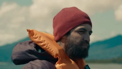 Gabriel Leone em cena do filme Barba Ensopada de Sangue (2026), usando gorro vermelho e colete salva-vidas.