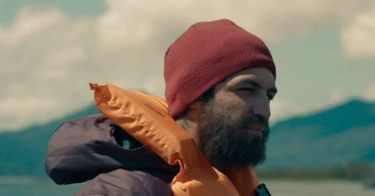 Gabriel Leone em cena do filme Barba Ensopada de Sangue (2026), usando gorro vermelho e colete salva-vidas.