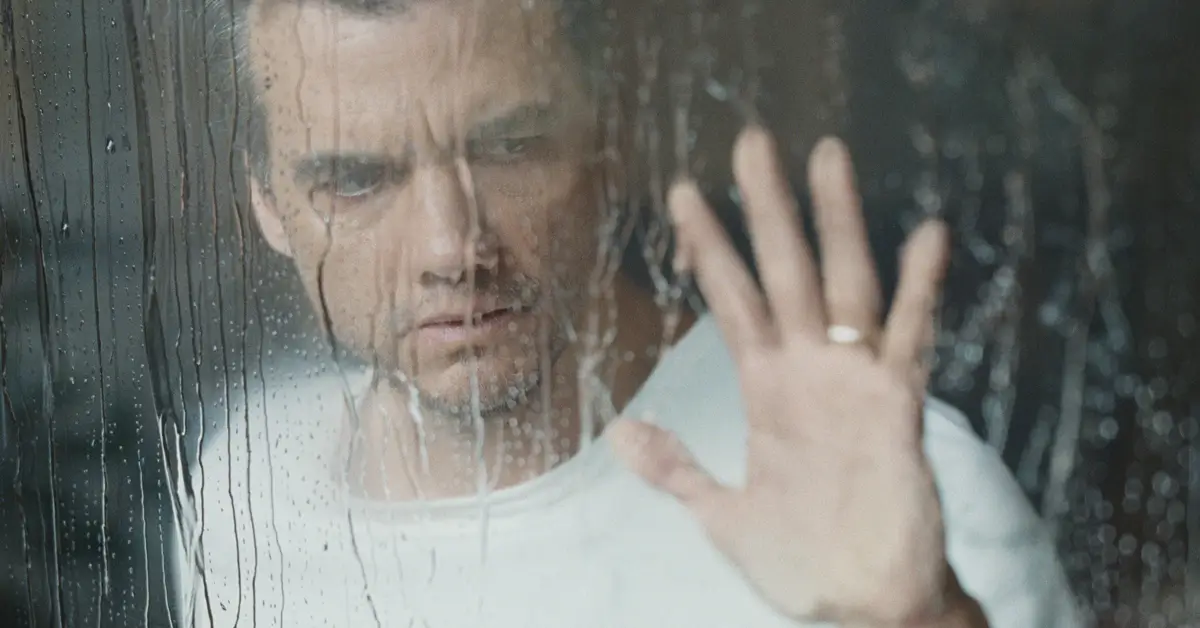 Wagner Moura em cena nas primeiras imagens de “A Última Casa” (2026), personagem observa através de vidro molhado em momento de tensão no terror da Netflix