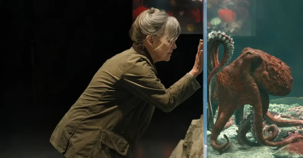 Sally Field observa um polvo em aquário em Criaturas Extraordinariamente Brilhantes (2026), filme da Netflix dirigido por Olivia Newman