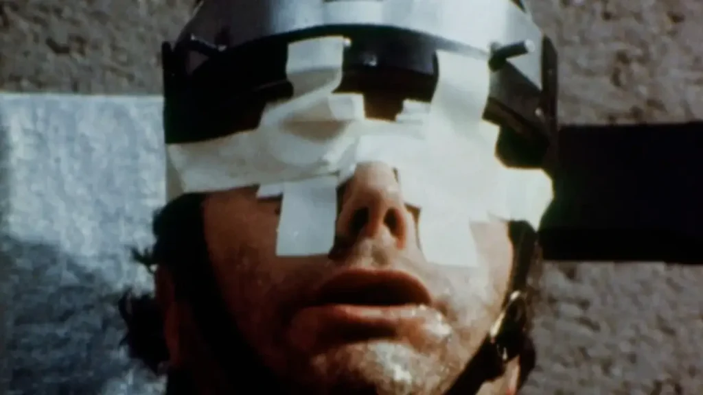Cena de Faces da Morte (1978) mostrando personagem em situação extrema, filme conhecido por sua controversa proposta pseudo-documental.
