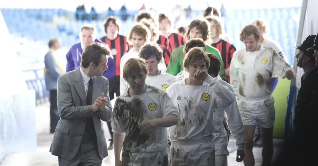 Maurice Roëves, Michael Sheen e Colin Harris em cena do filme sobre futebol Maldito Futebol Clube (2009), retratando bastidores do Leeds United