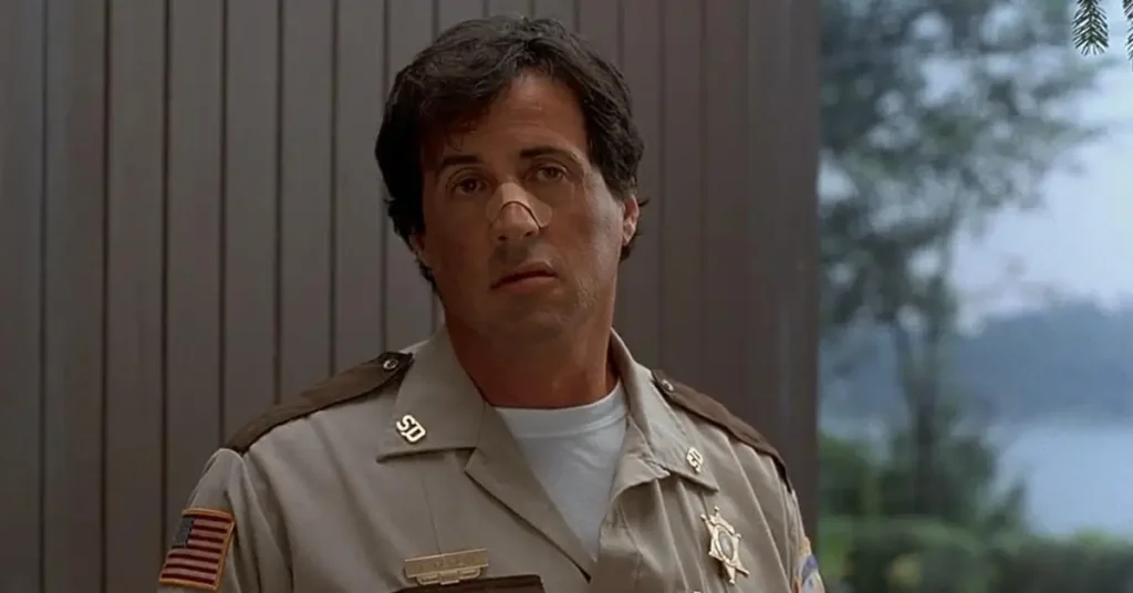 Sylvester Stallone como Freddy Heflin em Cop Land (1997) usando uniforme de xerife com expressão cansada