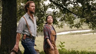 The Rivals of Amziah King trailer Matthew McConaughey e Angelina LookingGlass em cena do filme Os Rivais de Amziah King, caminhando por uma área rural cercada por árvores