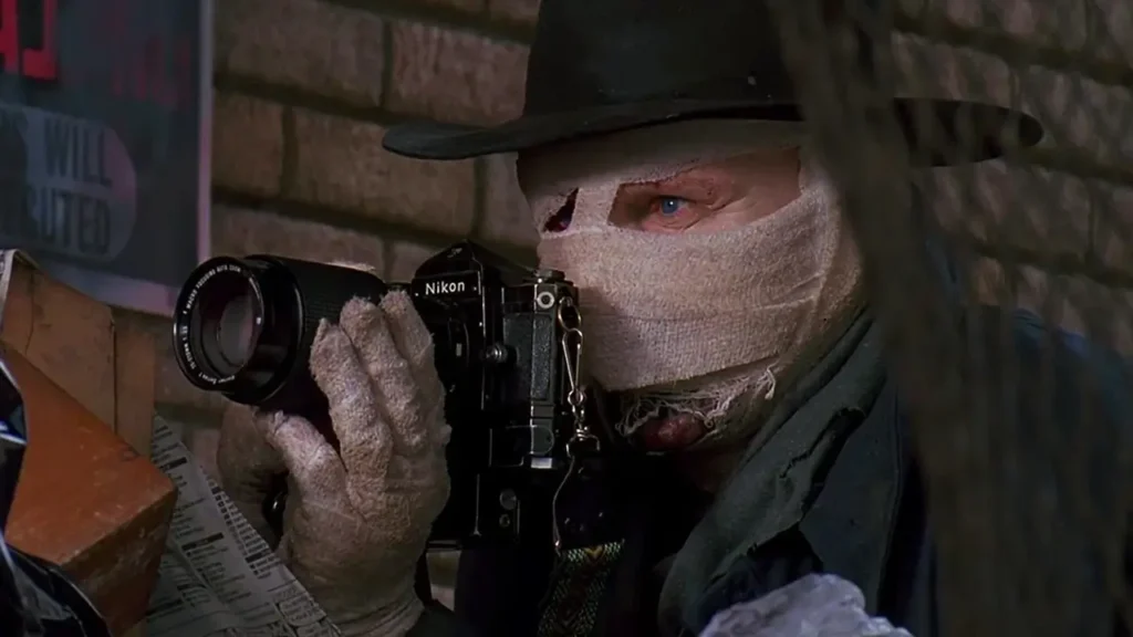 Liam Neeson como Peyton Westlake em Darkman (1990), personagem desfigurado após sofrer queimaduras provocadas por criminosos.