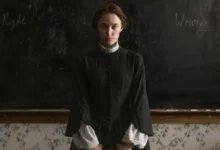 Maika Monroe em sala escura diante de um quadro-negro no filme de terror gótico Psicopata Vitoriana (2026)
