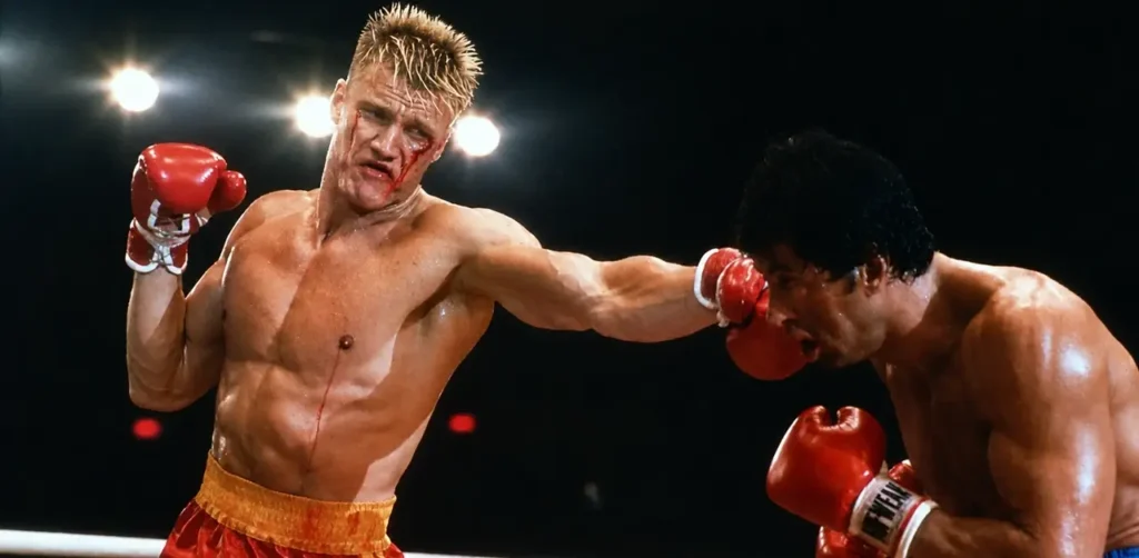 Dolph Lundgren e Sylvester Stallone em cena de luta de Rocky IV durante gravações que causaram grave lesão no ator
