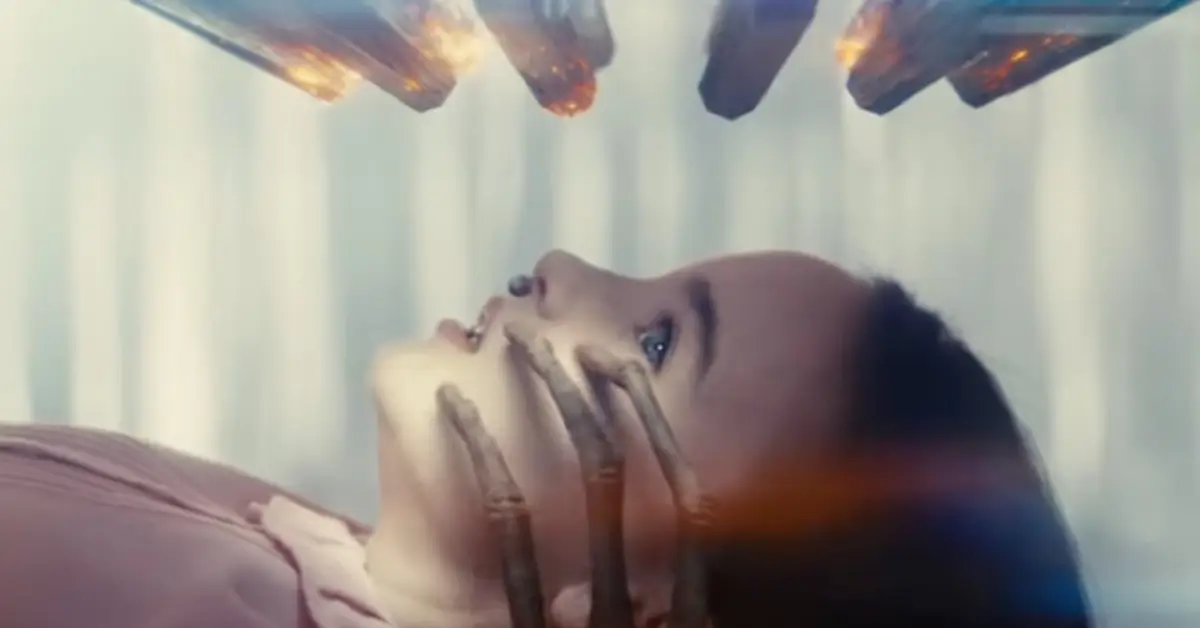 Cena do trailer final de Dia D mostra mulher deitada enquanto uma mão sombria cobre seu rosto em momento de suspense psicológico