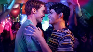 Joe Locke e Kit Connor dançam juntos e trocam sorrisos em uma festa iluminada por luzes coloridas em Heartstopper Para Sempre (2026), cena destacada no trailer de Heartstopper Para Sempre.