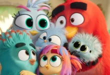 Personagens do filme Angry Birds 3: O Filme (2026) posicionados juntos em cena colorida, incluindo Red, pássaros azuis, Stella e outros personagens com expressões características