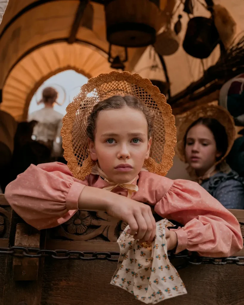 Alice Halsey como Laura Ingalls em uma carroça na série Uma Casa na Pradaria