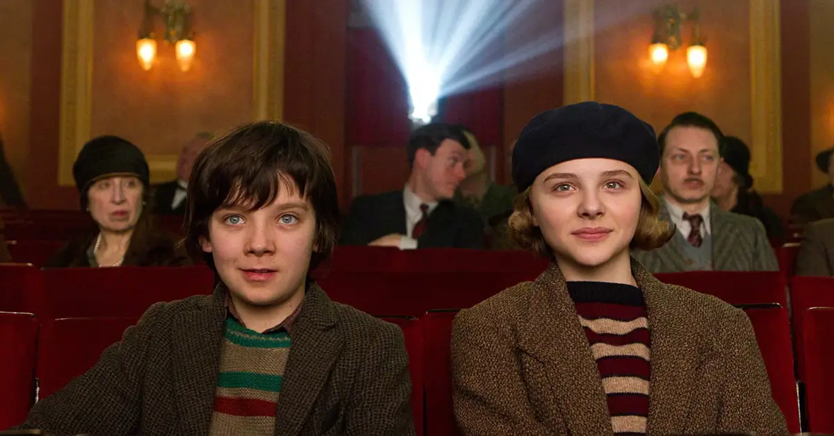 a invencao de hugo cabret sinopse Hugo Cabret e Isabelle assistem a uma sessão de cinema em cena de A Invenção de Hugo Cabret, dirigido por Martin Scorsese.