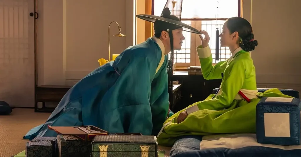 Son Ye-jin e Ji Chang-wook em uma cena de Escândalo e Intriga (The Scandal), novo K-drama histórico da Netflix ambientado na era Joseon; os atores aparecem caracterizados como Lady Cho e Jo Won em um ambiente tradiciona