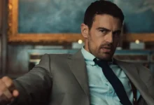 Theo James como Eddie Horniman em Magnatas do Crime: Temporada 2, usando terno e gravata em uma cena da série da Netflix.
