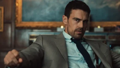 Theo James como Eddie Horniman em Magnatas do Crime: Temporada 2, usando terno e gravata em uma cena da série da Netflix.