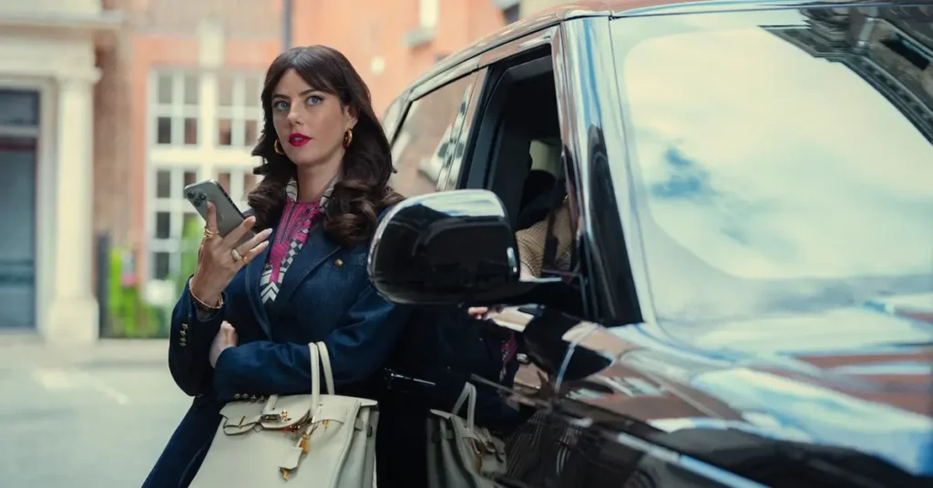 Kaya Scodelario como Susie Glass em cena de Magnatas do Crime: Temporada 2, série da Netflix, ao lado de um carro de luxo.