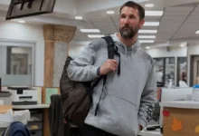 Cena de divulgação da 3ª temporada de The Pitt mostra um médico chegando ao pronto-socorro do hospital com uma mochila nas costas, enquanto o ambiente de atendimento aparece ao fundo.