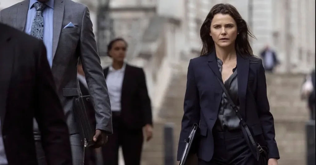 Keri Russell como Kate Wyler caminhando pelas ruas de Londres na quarta temporada de A Diplomata