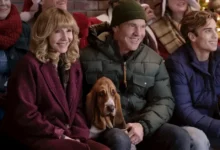 Dennis Quaid and Mary Steenburgen with a Basset Hound in a scene from Netflix’s A Dog’s Perfect Christmas, alongside other cast members at a holiday gathering.