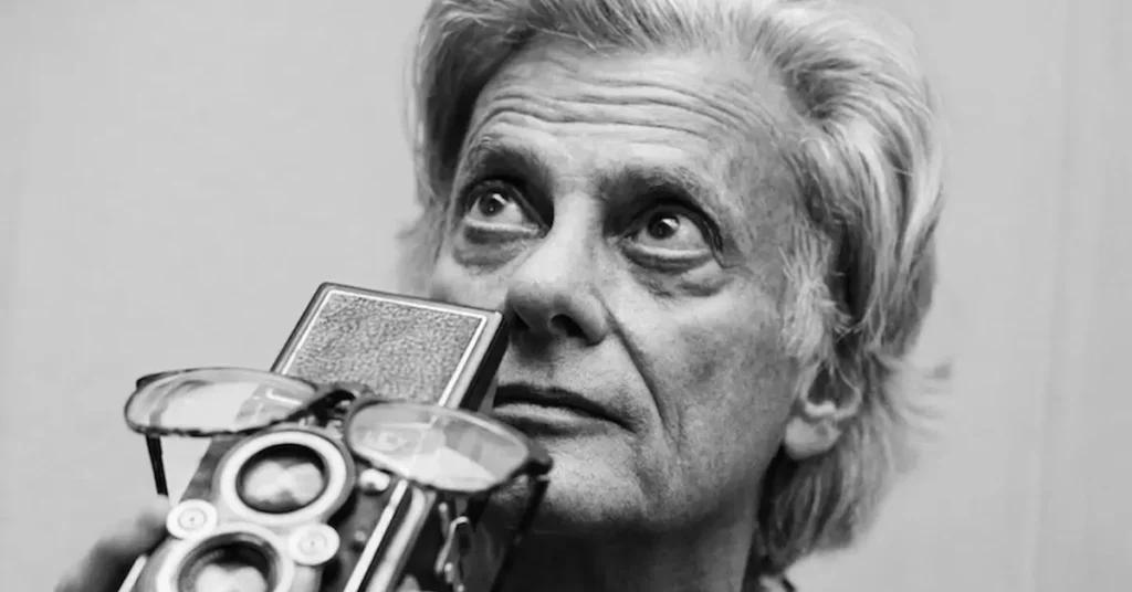 Fotógrafo Richard Avedon segura uma câmera fotográfica em retrato em preto e branco exibido no documentário Avedon.