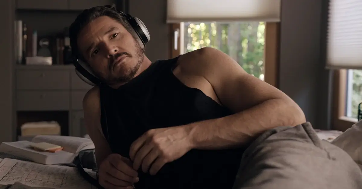 Pedro Pascal em cena de Behemoth: Uma Vida Composta em Peças, deitado na cama com fones de ouvido, partituras e anotações ao lado