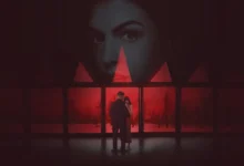 Cena de Verity (2026) com casal diante de janelas e rosto de mulher ao fundo em atmosfera vermelha