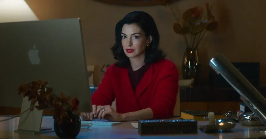 Anne Hathaway em Verity (2026), sentada diante de um computador em ambiente doméstico