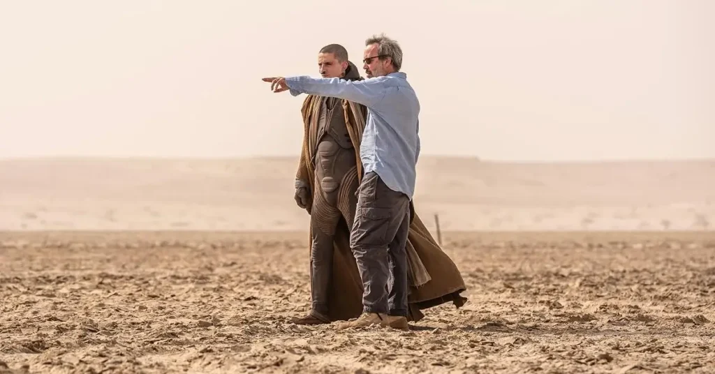 Denis Villeneuve orienta Timothée Chalamet durante as filmagens de Duna: Parte 3 (2026), em um cenário desértico.