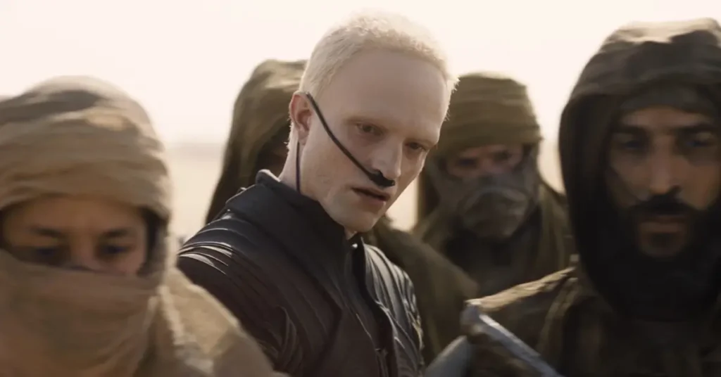 Robert Pattinson como Scytale em cena de Duna: Parte 3 (2026), ao lado de personagens com vestimentas de Arrakis.