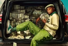 Samuel L. Jackson como Russell Lee Washington Jr. em Frisco King (2026), sentado no porta-malas de um carro cercado por dinheiro.