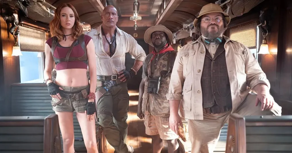 Karen Gillan, Dwayne Johnson, Kevin Hart e Jack Black caracterizados como seus personagens em Jumanji: Mundo Real (2026), dentro de um vagão de trem.