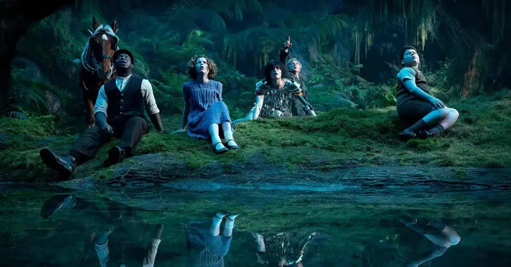 Daniel Craig, Kobna Holdbrook-Smith, David McKenna, Beatrice Campbell e Emma Mackey em cena de Nárnia: O Sobrinho do Mago (2027), reunidos em uma floresta fantástica à beira de um lago.