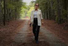 Jessica Chastain em cena de No Coração de Nashville (2026), caminhando por uma estrada cercada por árvores