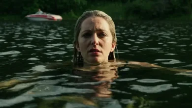 Jessica Rothe em cena no filme River (2026), com a atriz dentro de um lago.