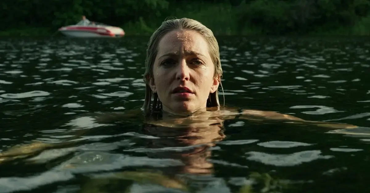 Jessica Rothe em cena no filme River (2026), com a atriz dentro de um lago.