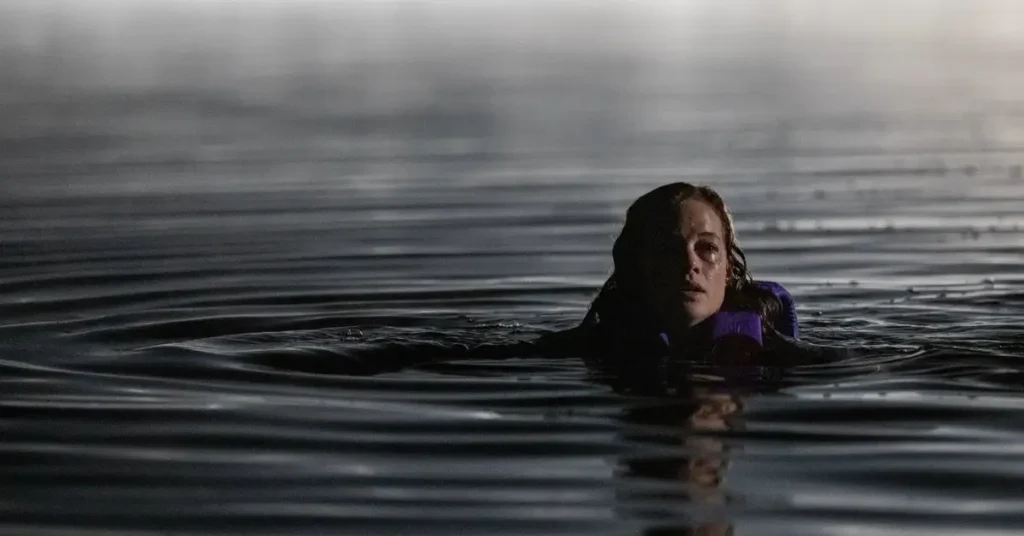 Jane Levy em cena do filme de terror River (2026), lutando para sobreviver dentro de um rio.